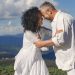 Smiling couple embracing in a picturesque mountain setting, capturing a joyful moment together.